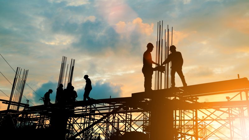 Silhouette of engineer and construction team working at site over blurred background sunset pastel for industry background with Light fair.Create from multiple reference images together.